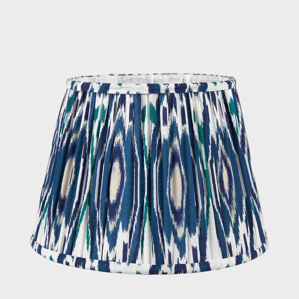 A tapered lampshade with a mushroom pleat design featuring a colorful blue ikat pattern.