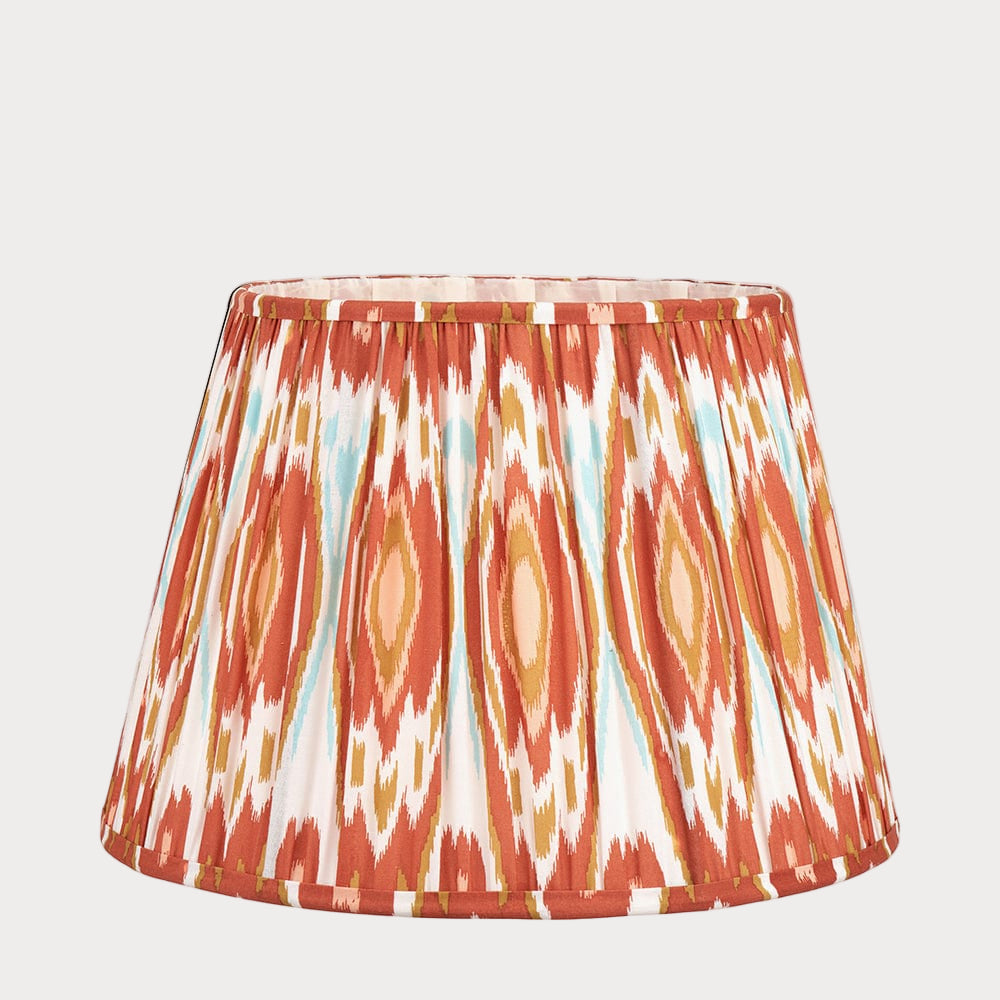 A tapered lampshade with a mushroom pleat design featuring a colorful ikat pattern.
