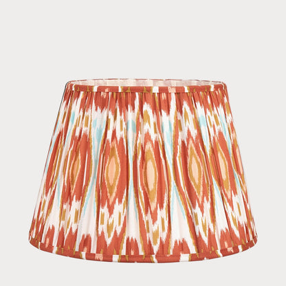 A tapered lampshade with a mushroom pleat design featuring a colorful ikat pattern.