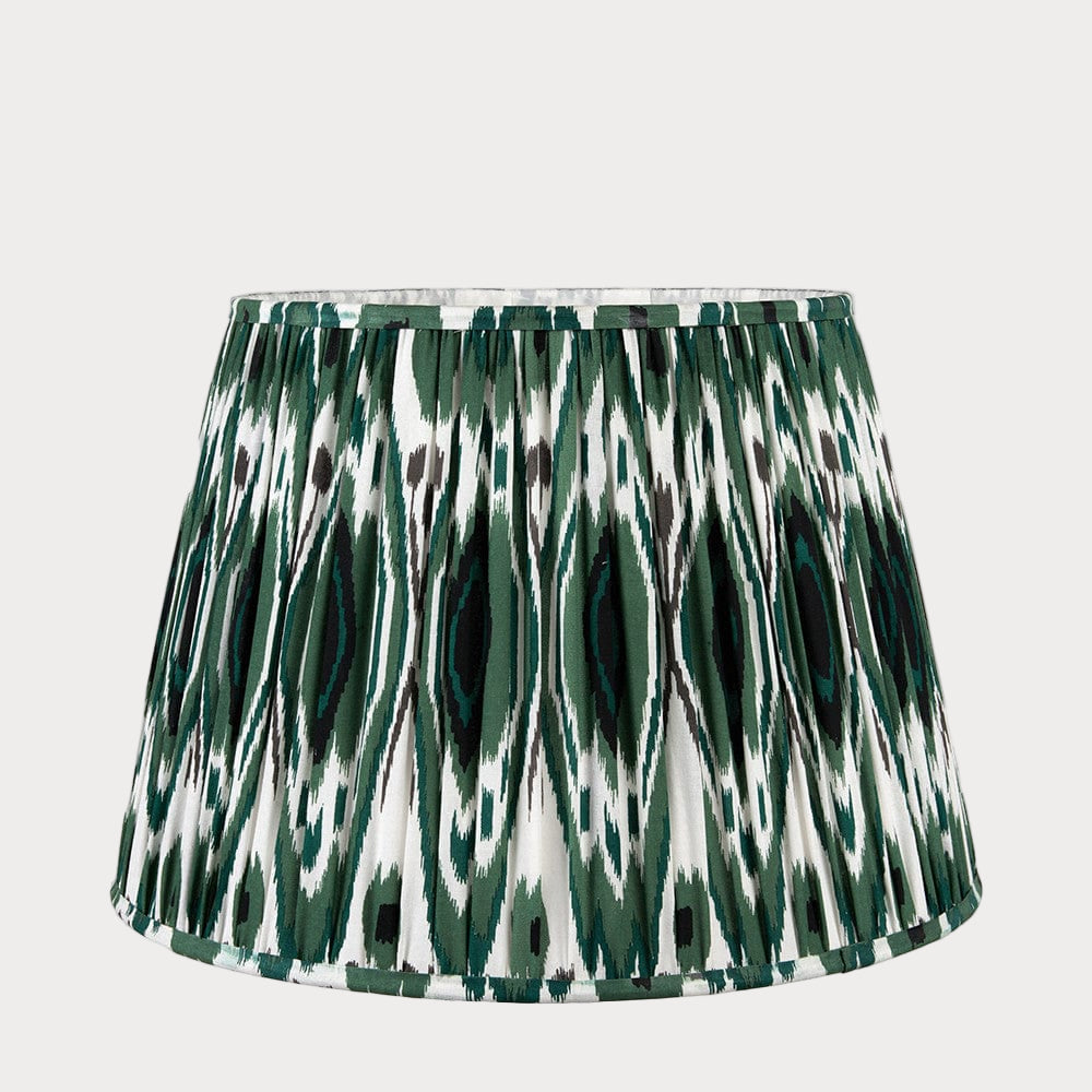 A tapered lampshade with a mushroom pleat design featuring a colorful green ikat pattern.