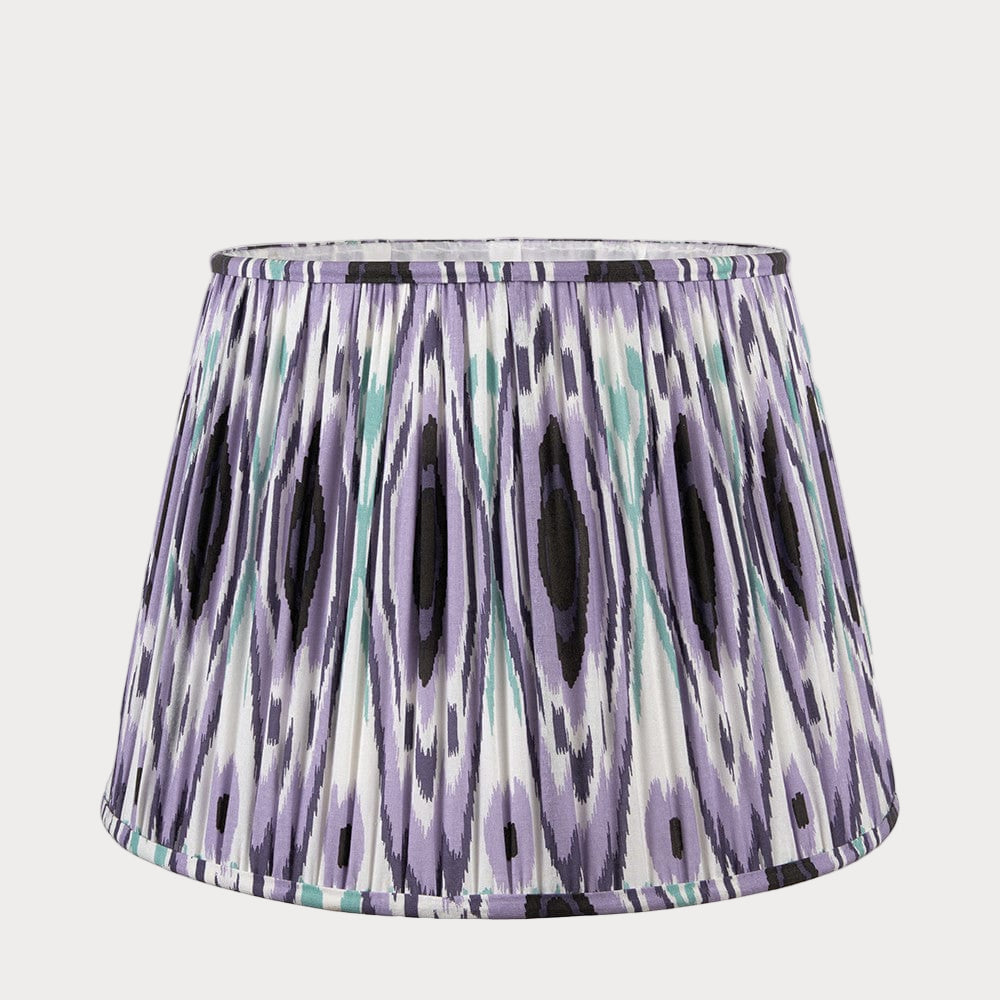 A tapered lampshade with a mushroom pleat design featuring a colorful purple ikat pattern.
