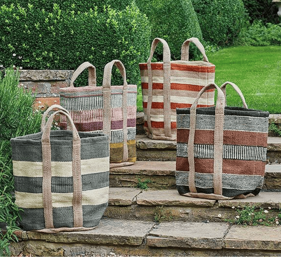 Set of striped fabric baskets on stone steps with a garden background