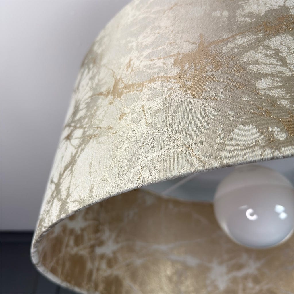 Close-up of a textured lampshade with a light bulb inside, on a neutral background