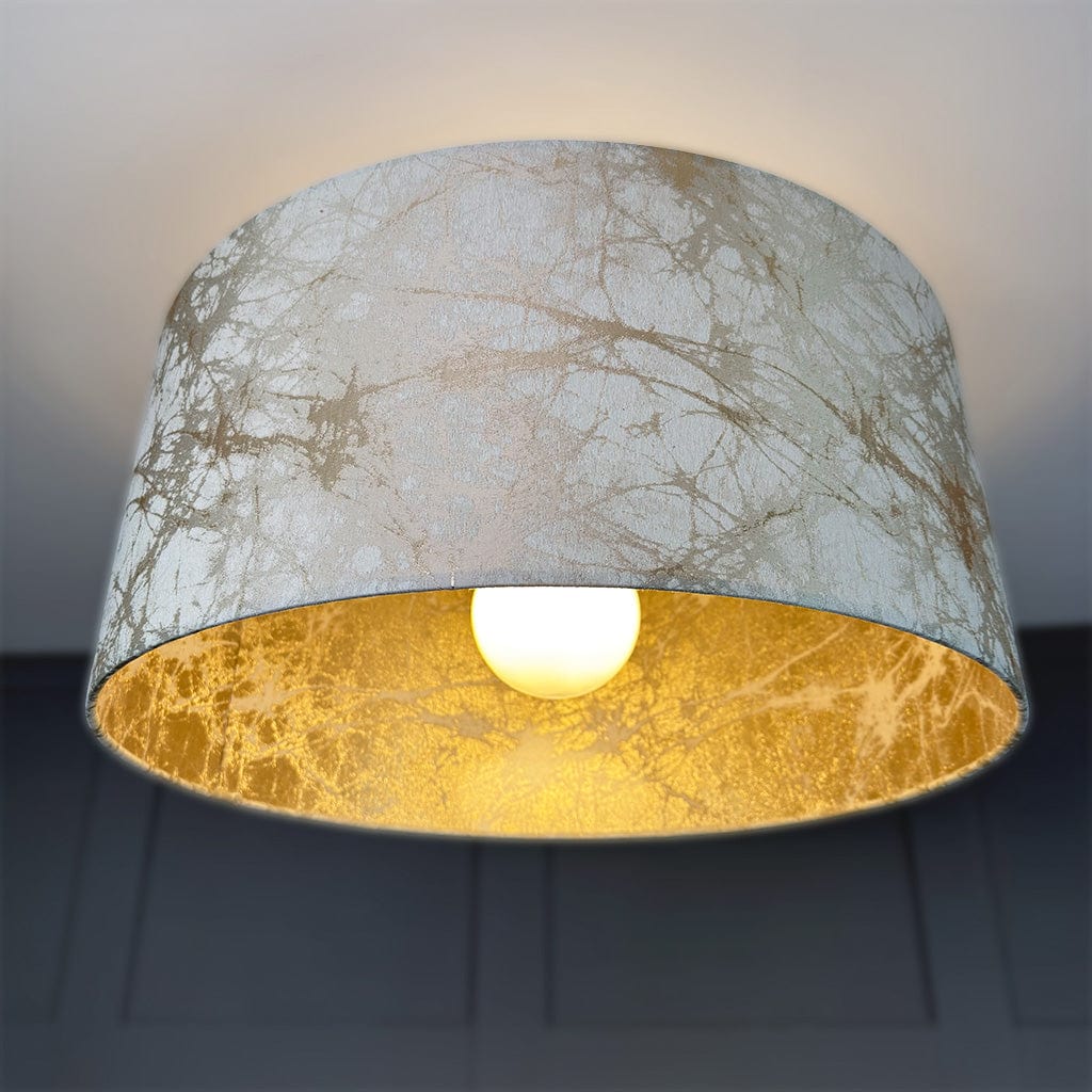 Lampshade with marble texture and gold interior on a dark background