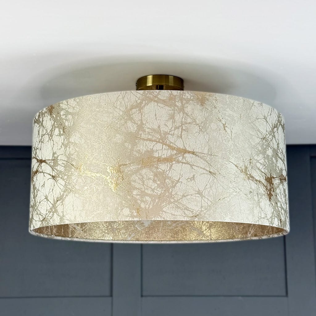 Ceiling light fixture with marbleized lave like cream and gold design on a neutral background