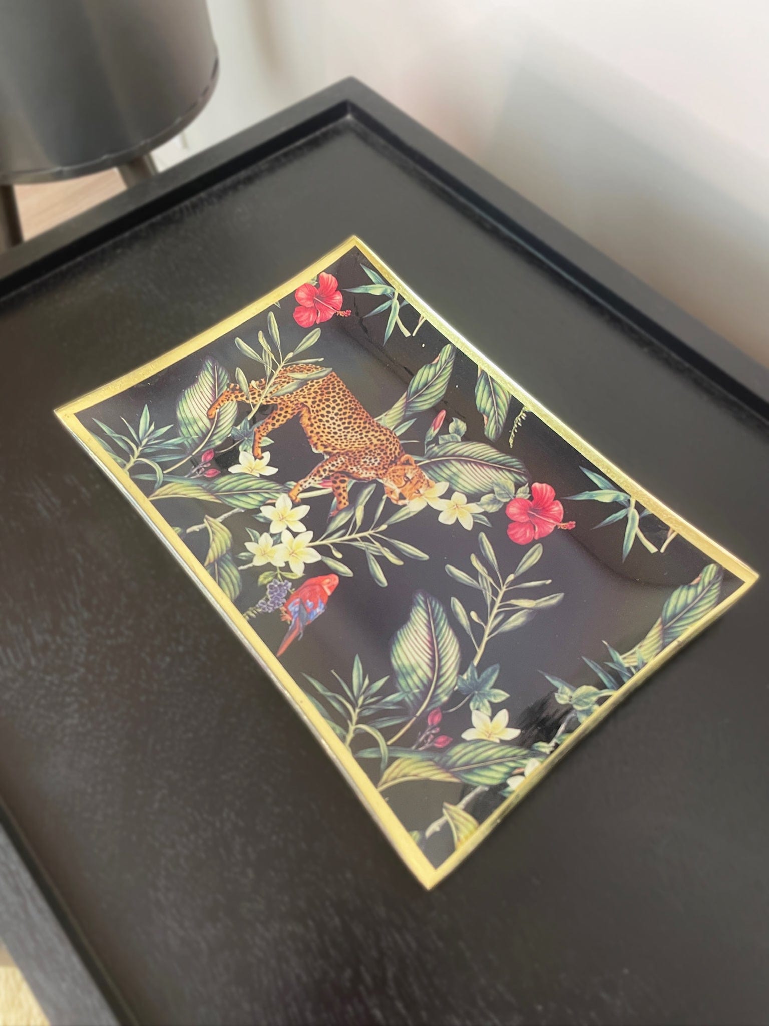 Decorative tray with floral and animal design on a black surface