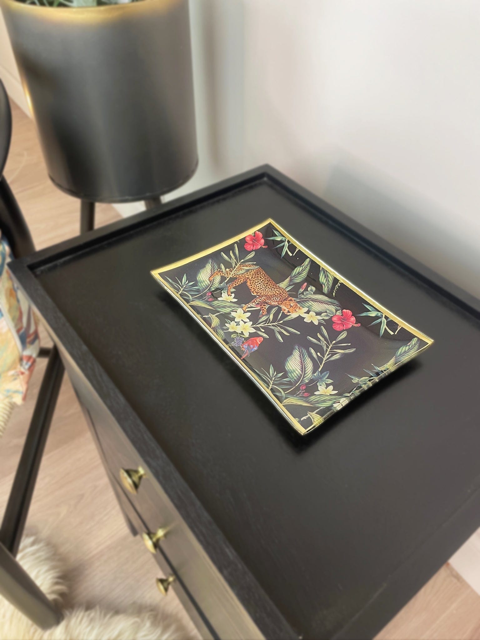 Decorative tray with floral and animal design on a black surface
