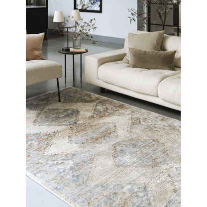 A persian style rug on a floor in a room in front of a sofa