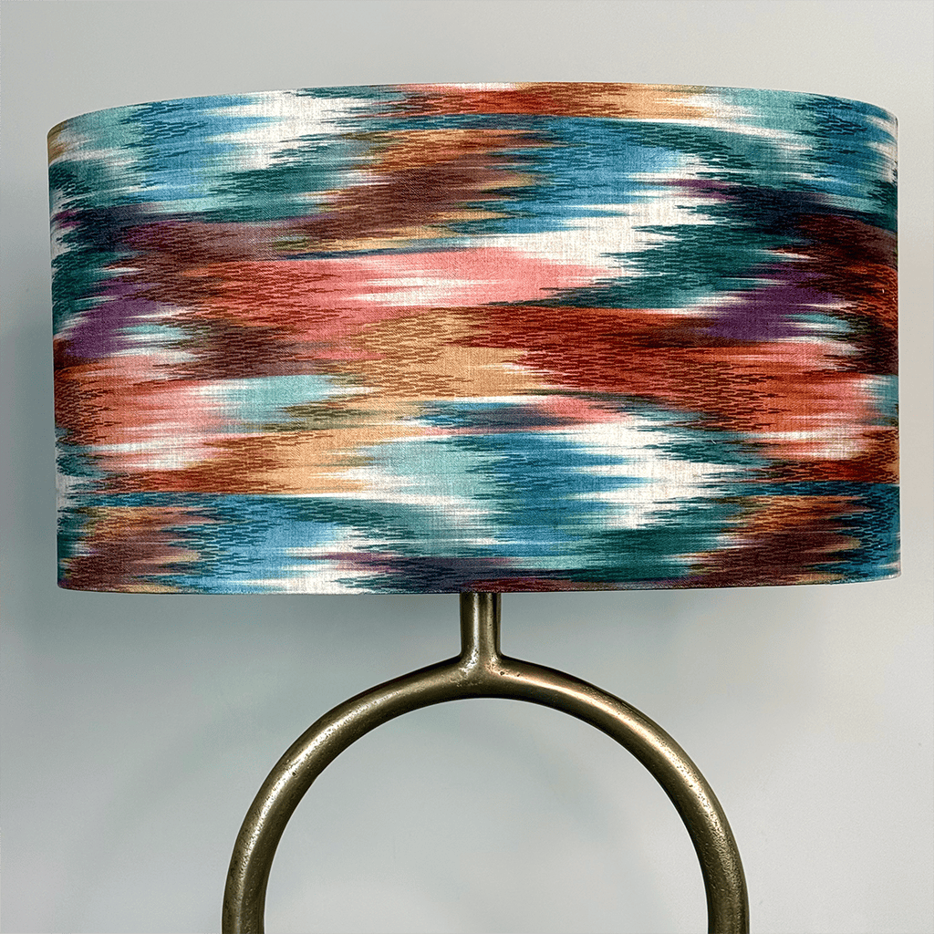 Lamp with a multicolored shade and metallic base on a light gray background