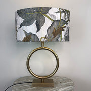 Table lamp with a decorative leaf-patterned shade on a marble surface.