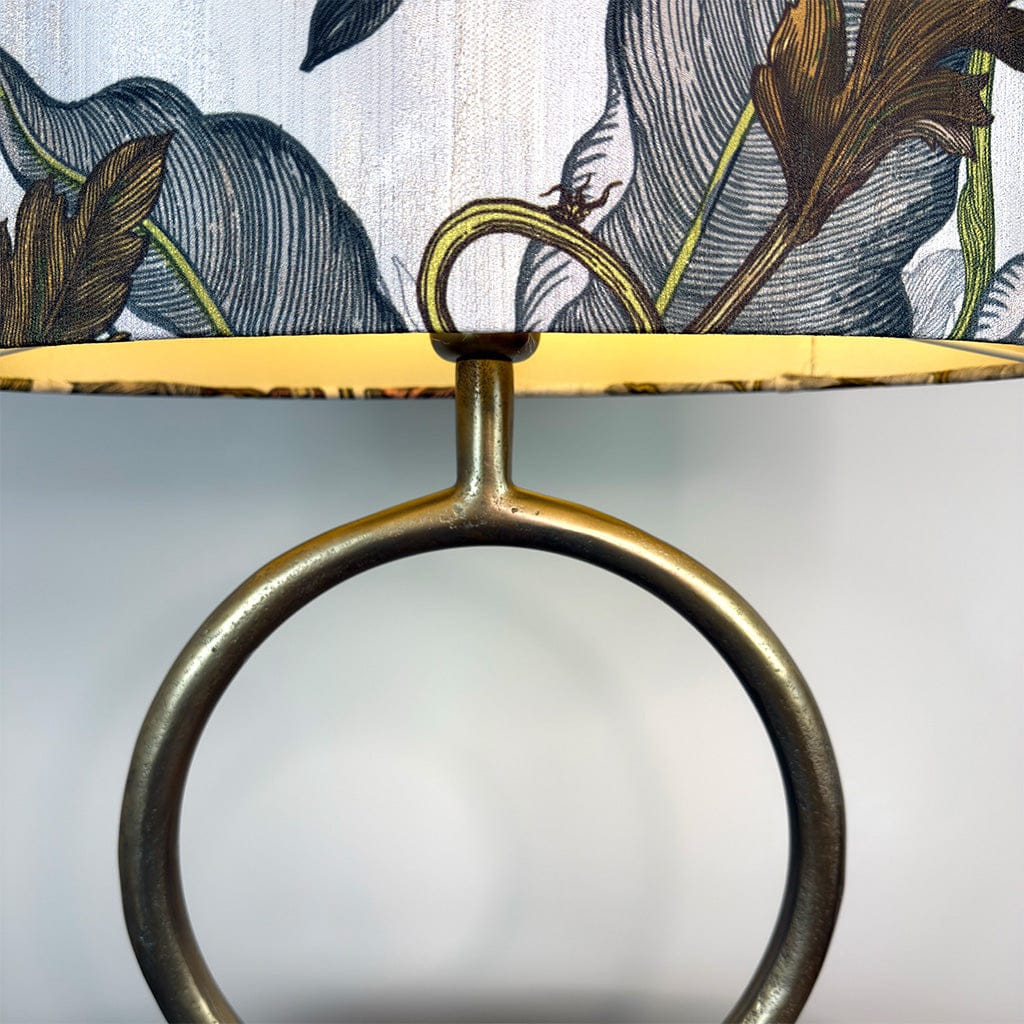 Decorative stand with floral patterned fabric and brass ring design.