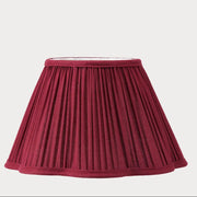 Maroon pleated lampshade on a light
 background