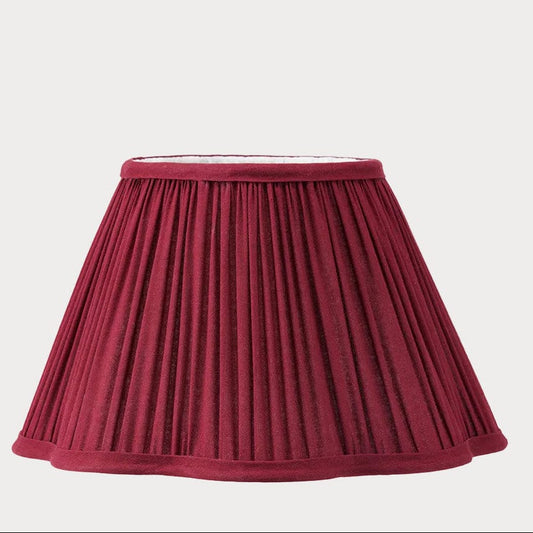 Maroon pleated lampshade on a light
 background