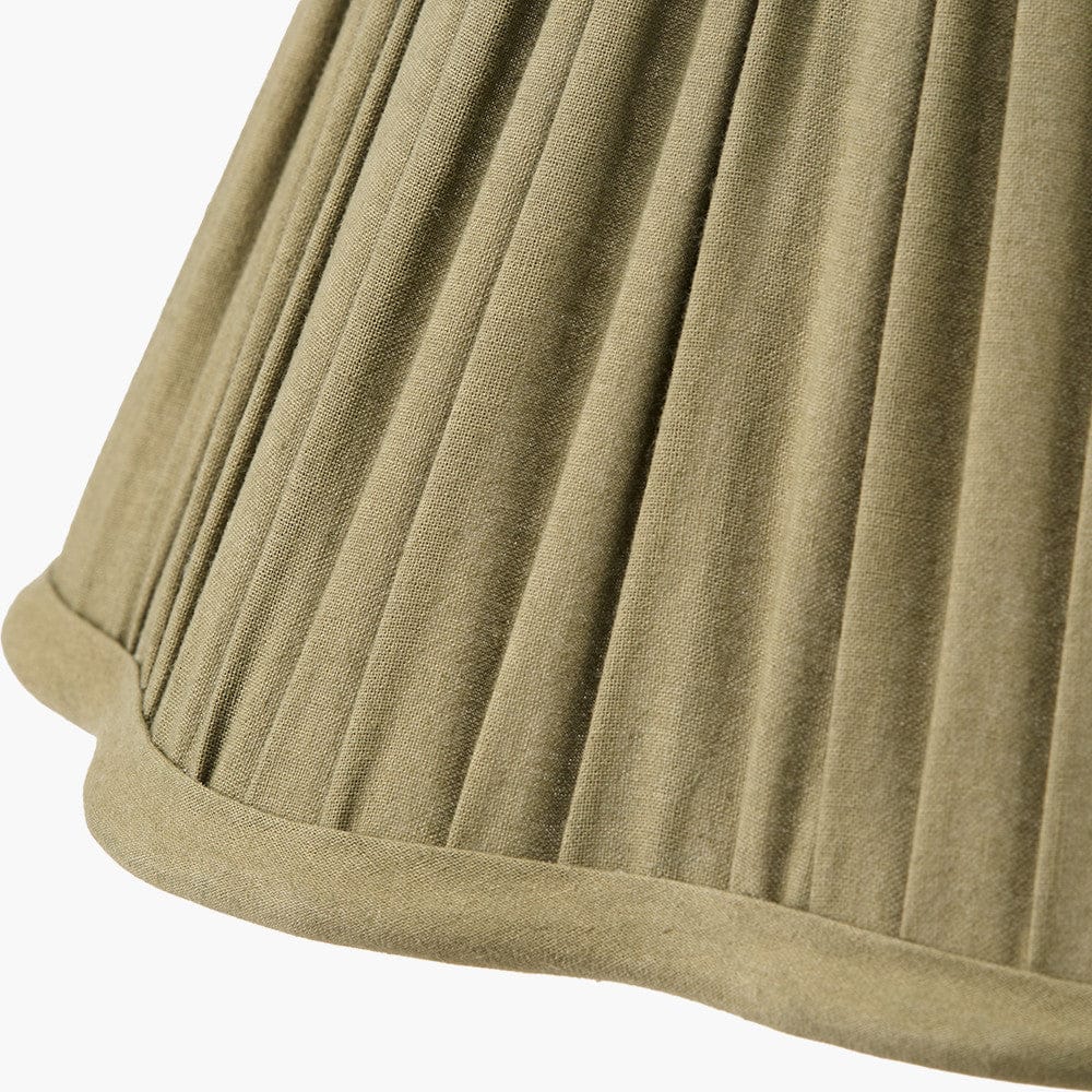 Close-up of a pleated green fabric skirt on a white background