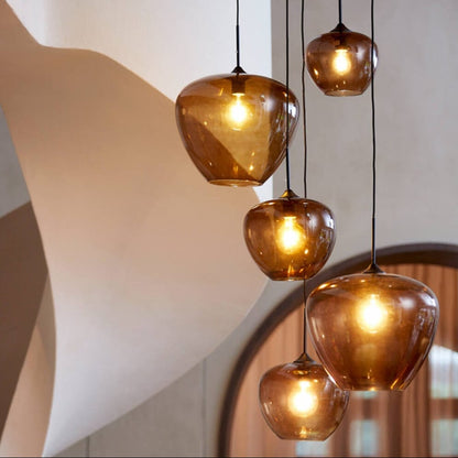 Set of hanging pendant lights with glass shades in a modern interior setting.