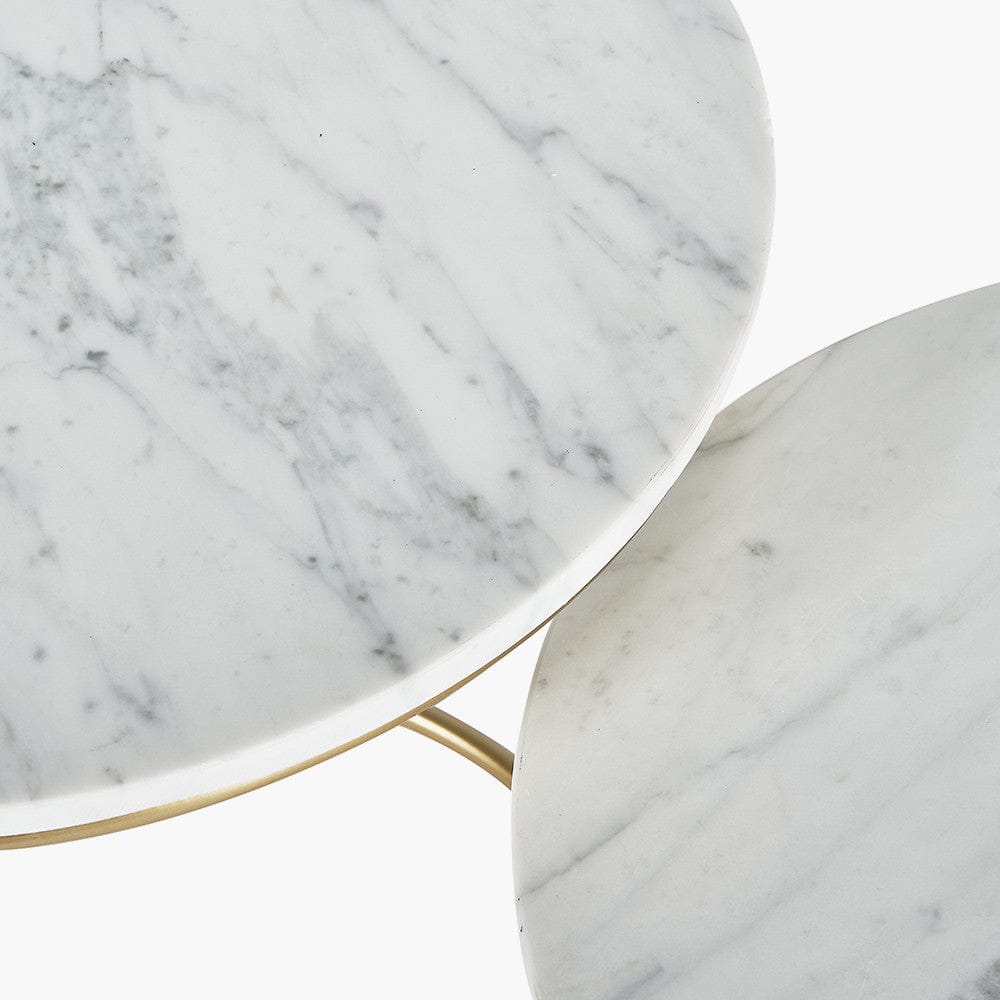 Close-up of two marble coffee tables with a gold accent.