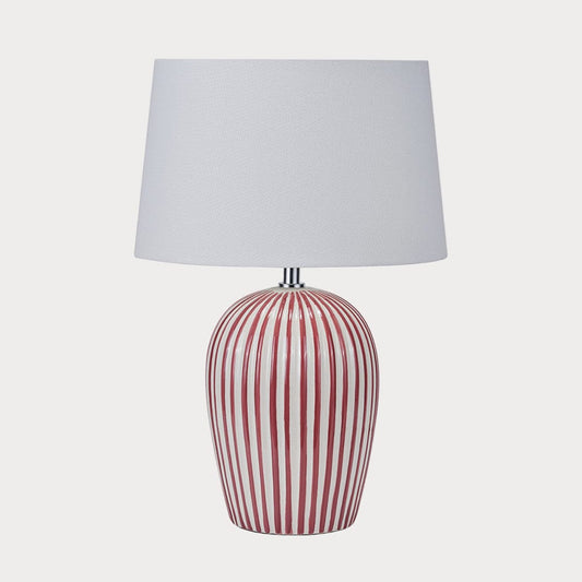 Table lamp with red and white striped base and gray shade on a white background