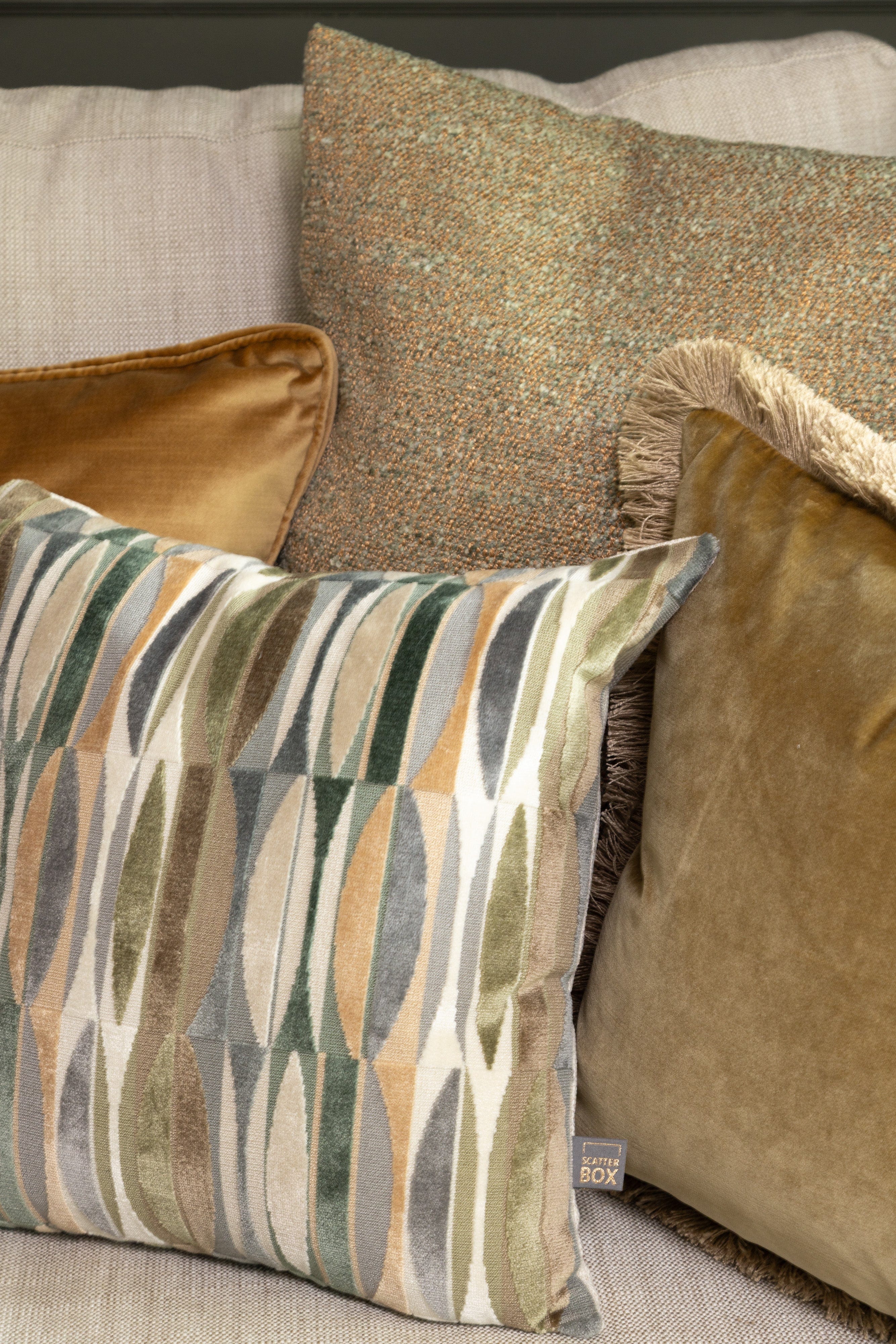 Patterned pillow on a sofa with other pillows in the background