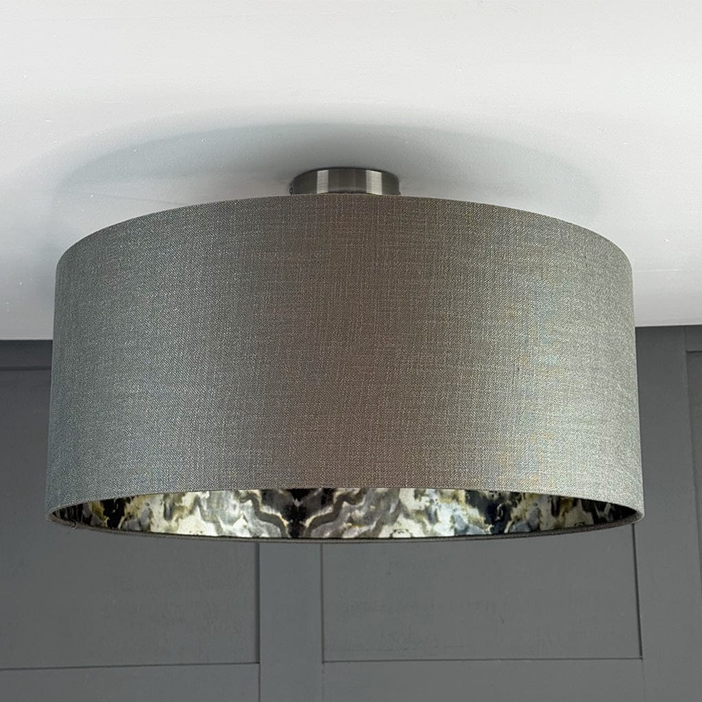 Ceiling light fixture with a gray lampshade against a gray wall.