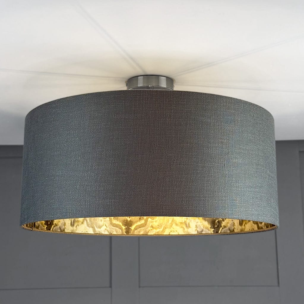 Ceiling light fixture with a dark gray shade and gold interior on a neutral background
