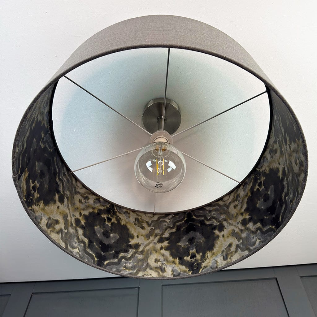 Ceiling light fixture with decorative shade and visible bulb