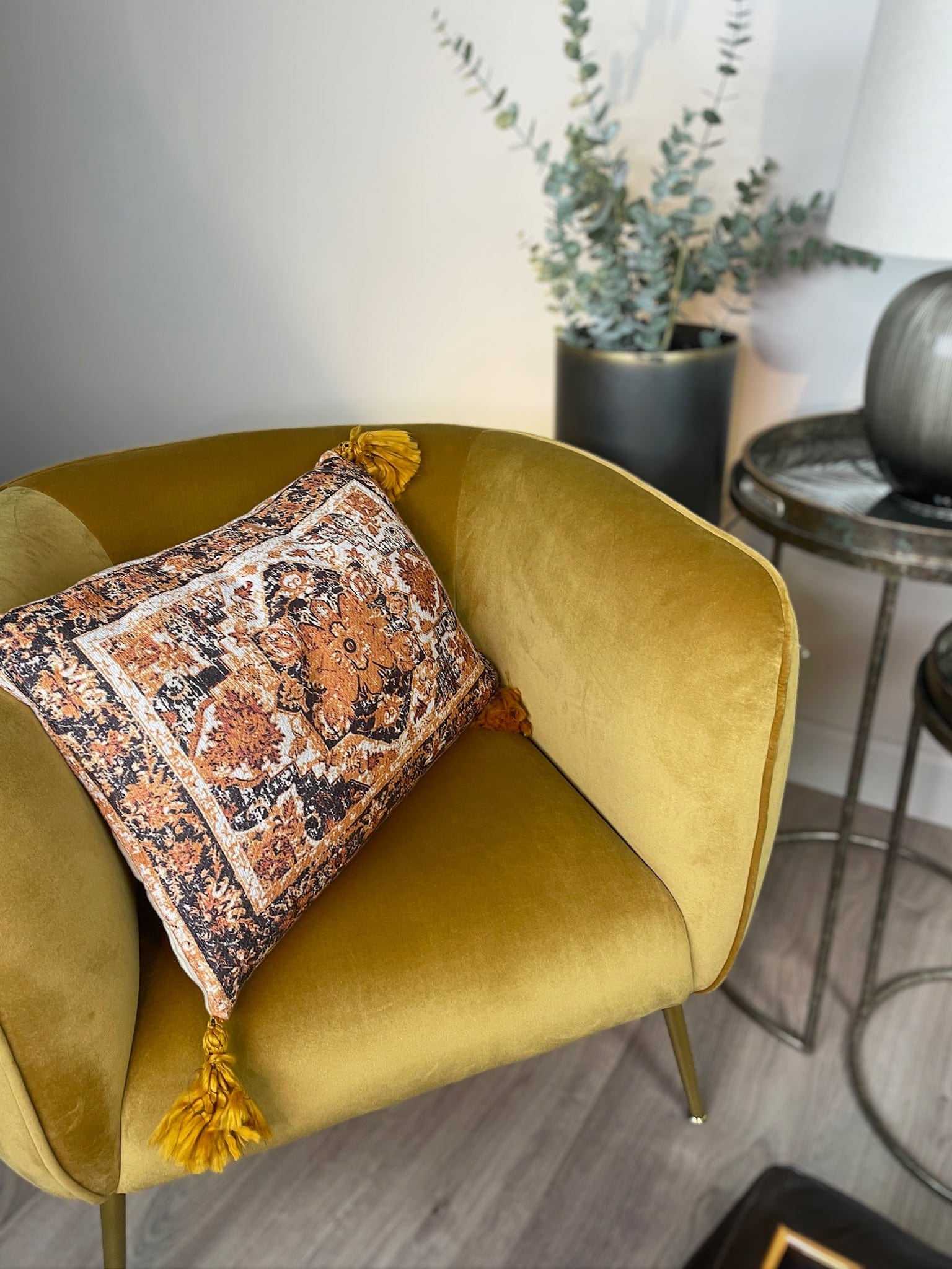Yellow armchair with a patterned pillow in a room setting