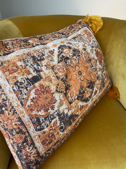 Decorative pillow with intricate patterns on a yellow sofa