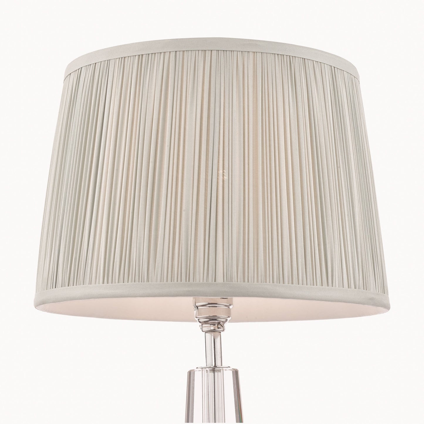 Table lamp with a pleated silver shade on a white background