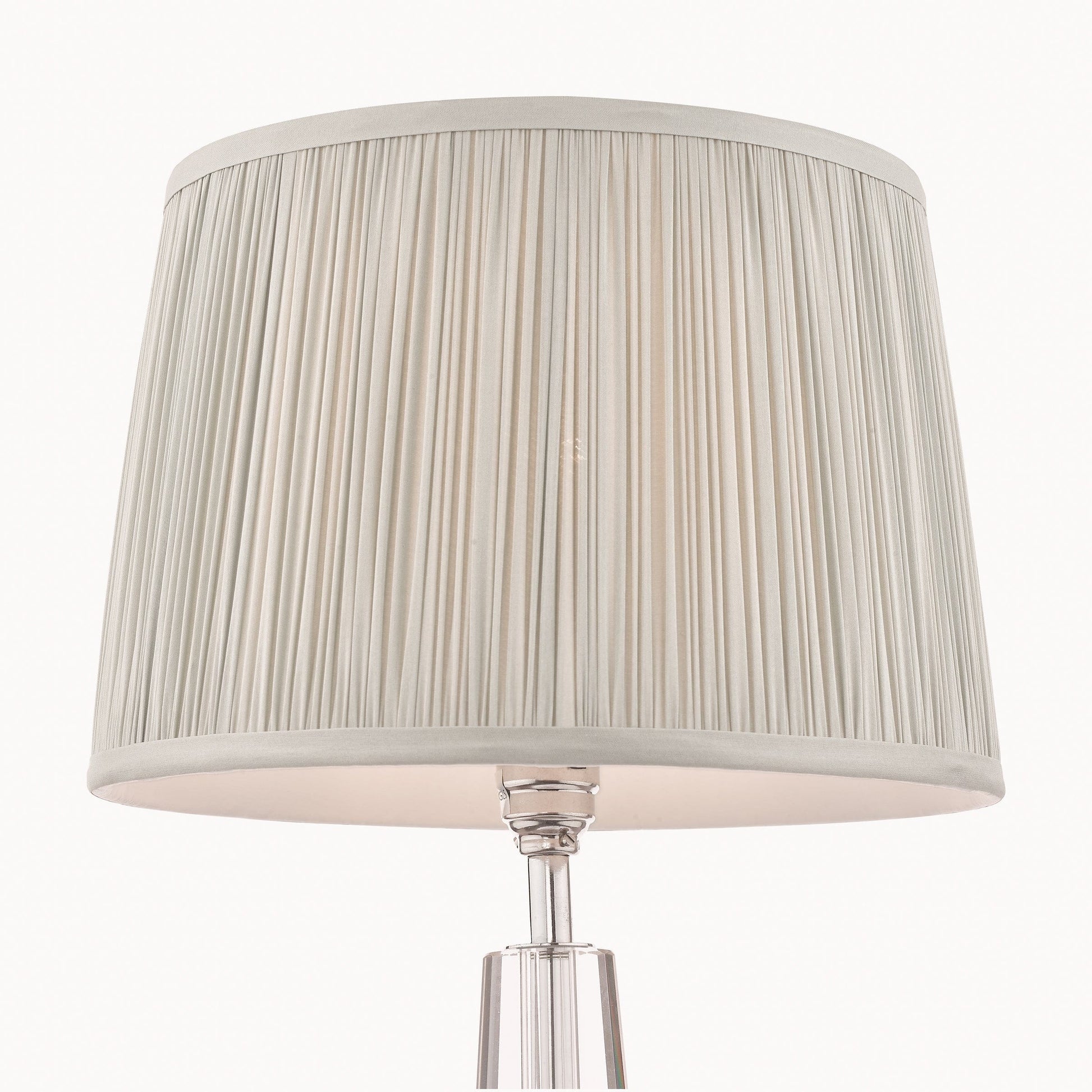 Table lamp with a pleated silver shade on a white background