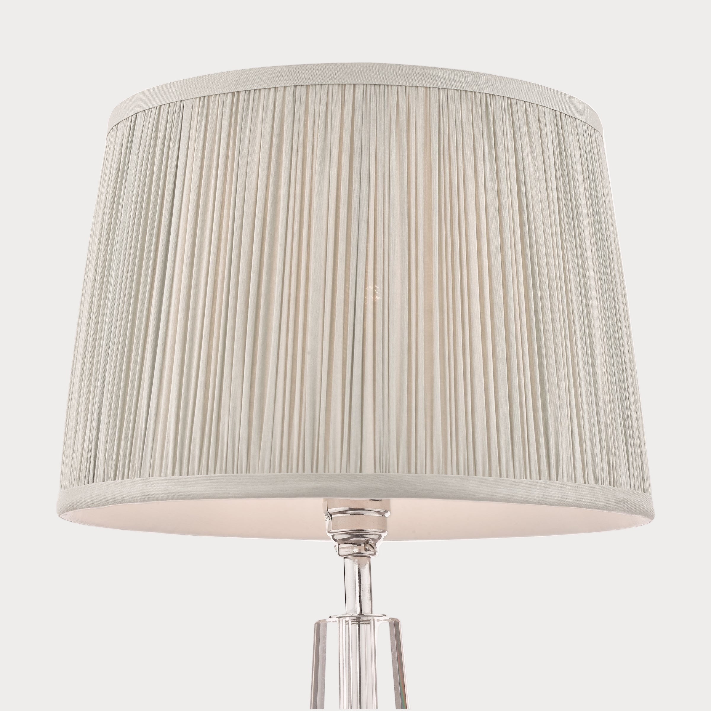 Table lamp with a pleated silver shade on a white background