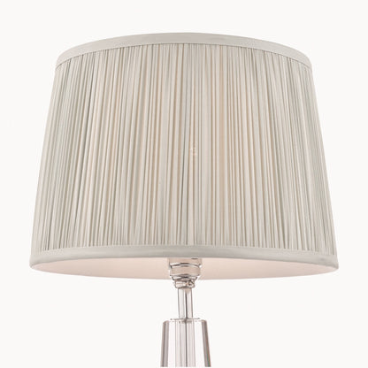 Table lamp with a pleated silver shade on a white background