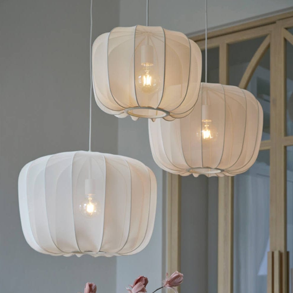 Three hanging pendant lights with a decorative table setting in the foreground.