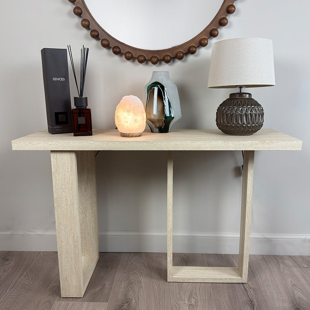 Wooden console table with decorative items against a plain wall