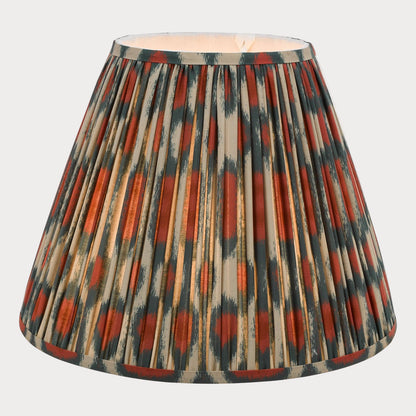 A tapered shade with a bold red and green ikat pattern on a cotton fabric, suitable for chandeliers or wall light fixtures.