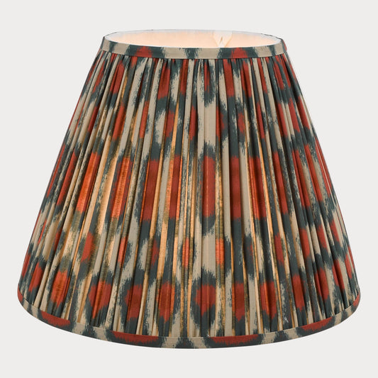 A tapered shade with a bold red and green ikat pattern on a cotton fabric, suitable for chandeliers or wall light fixtures.