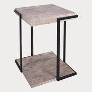 A square side table with a concrete effect top and black angular legs.