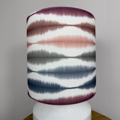 Decorative lamp with a patterned shade on a plain background