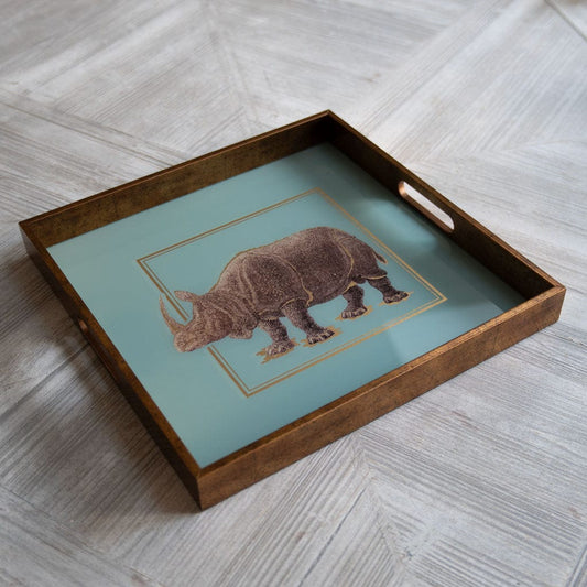 A square-shaped tray with a rhino design on a teal background, framed with a gold-tone border and wooden edges.