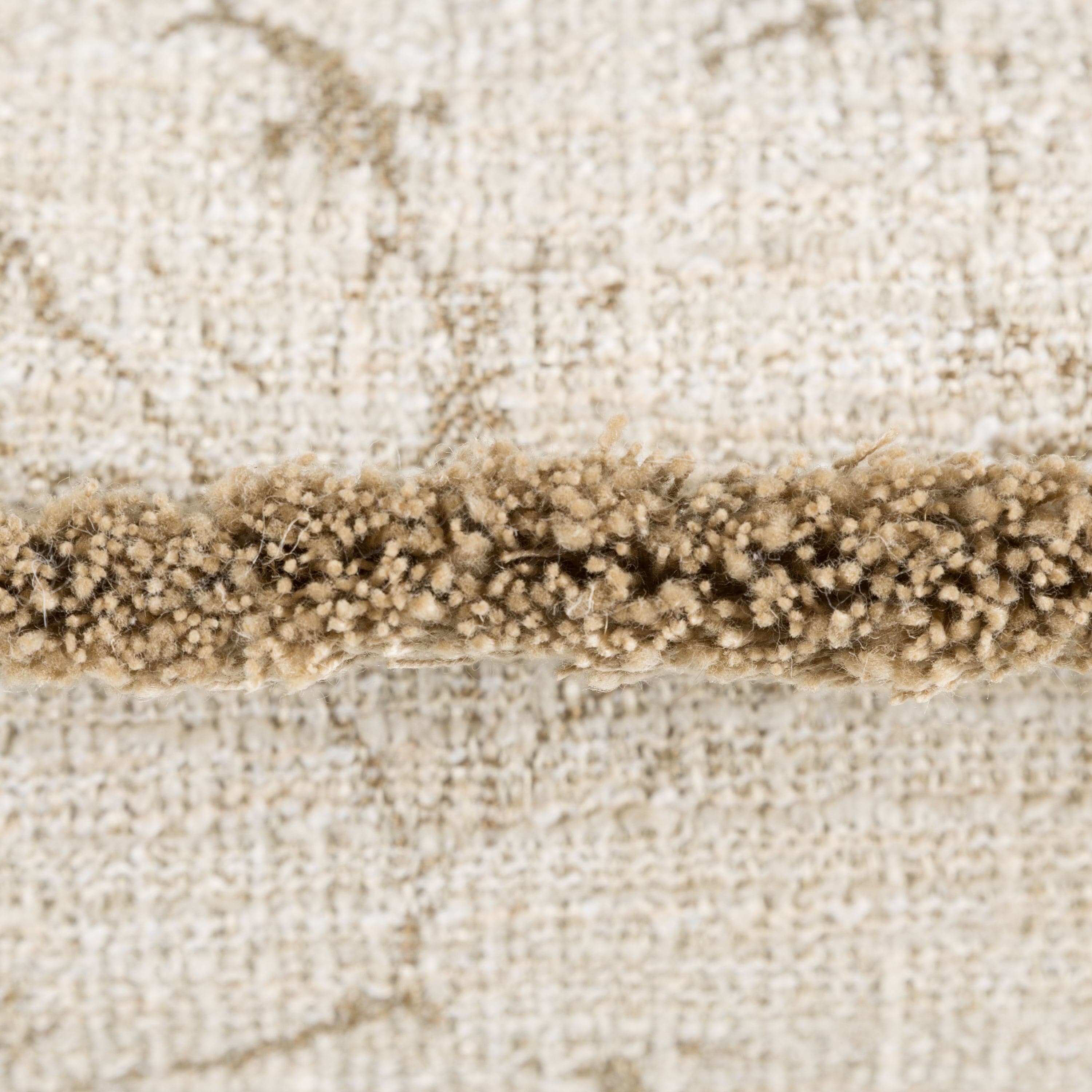 Close-up of a beige cushion with a trimmed edge and a beige pattern