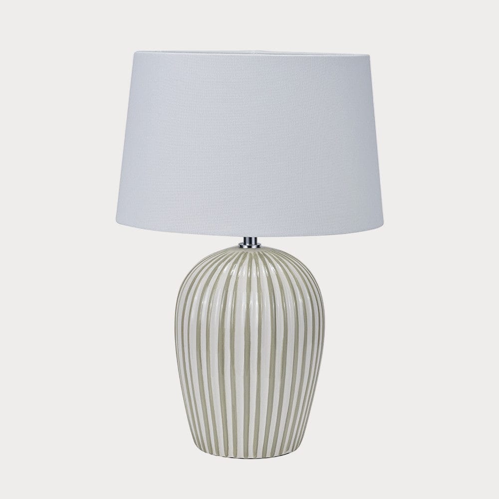 Table lamp with a striped ceramic base and white shade on a white background