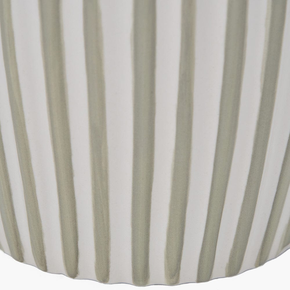 Close-up of a fabric with green and white vertical stripes on a white background
