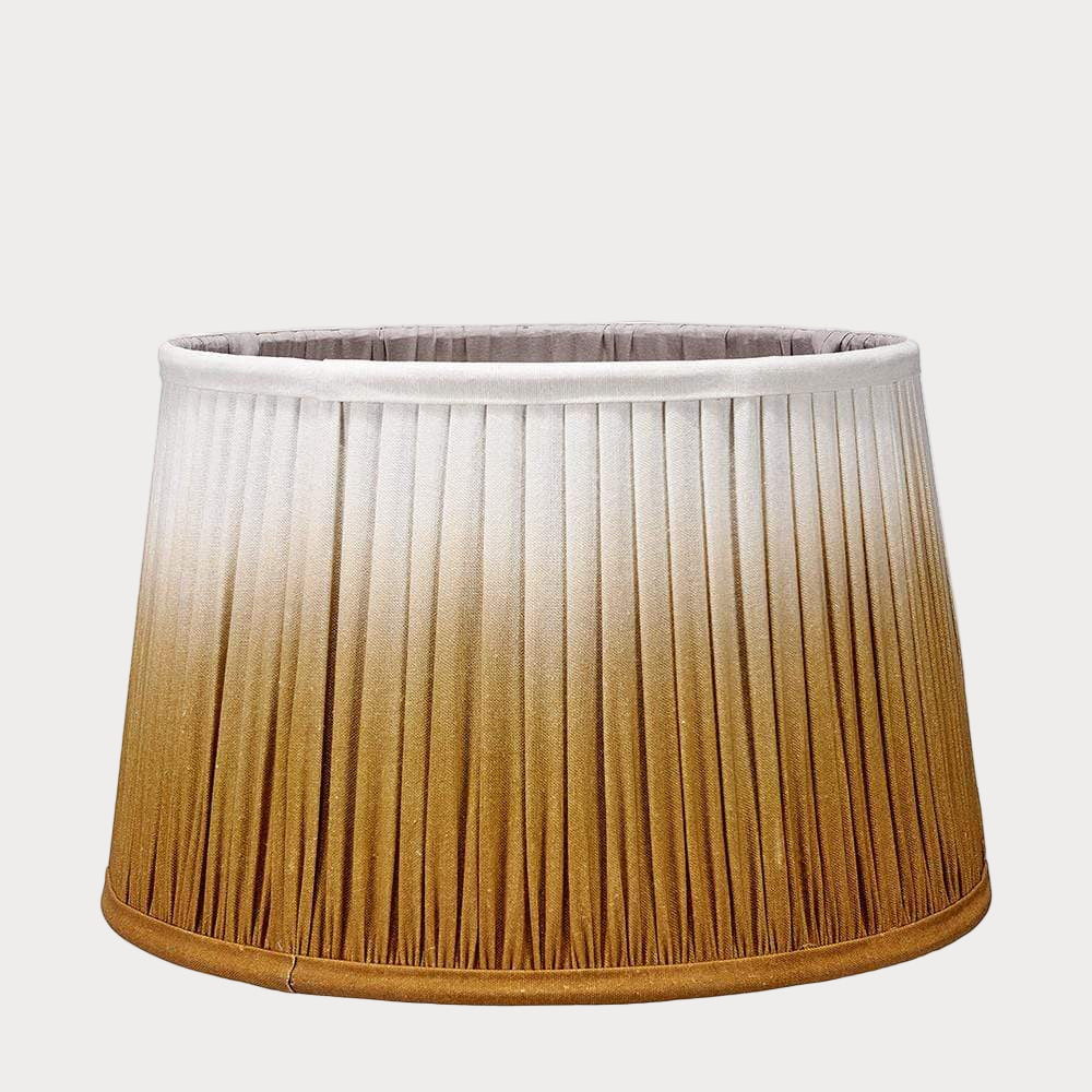 A pleated tapered shade with a ombre gradient color design, transitioning from white to mustard.