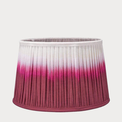 A pleated tapered shade with a ombre gradient color design, transitioning from white to raspberry red.