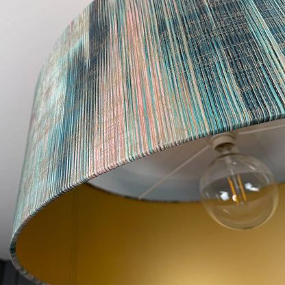 Close-up of a lamp with a striped shade and visible bulb.
