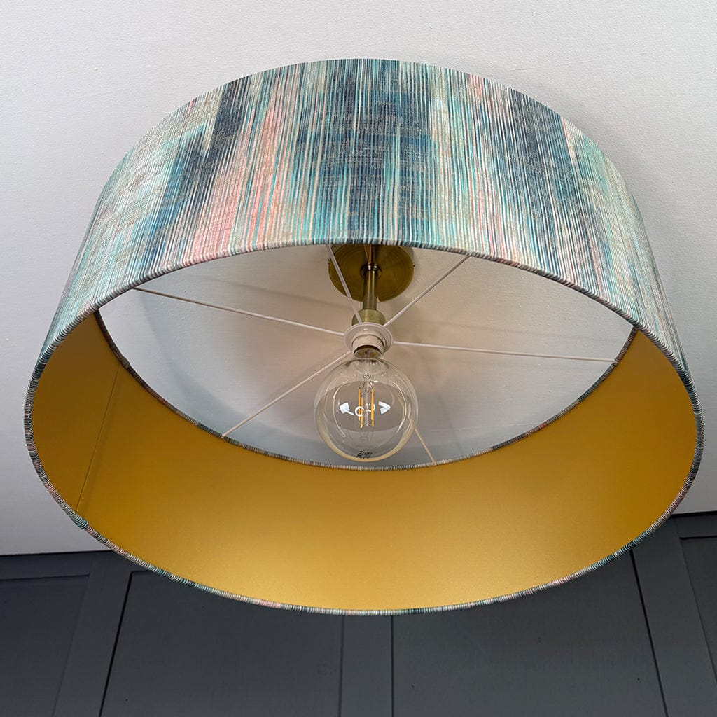 Lamp with a multicolored shade and yellow base on a plain background