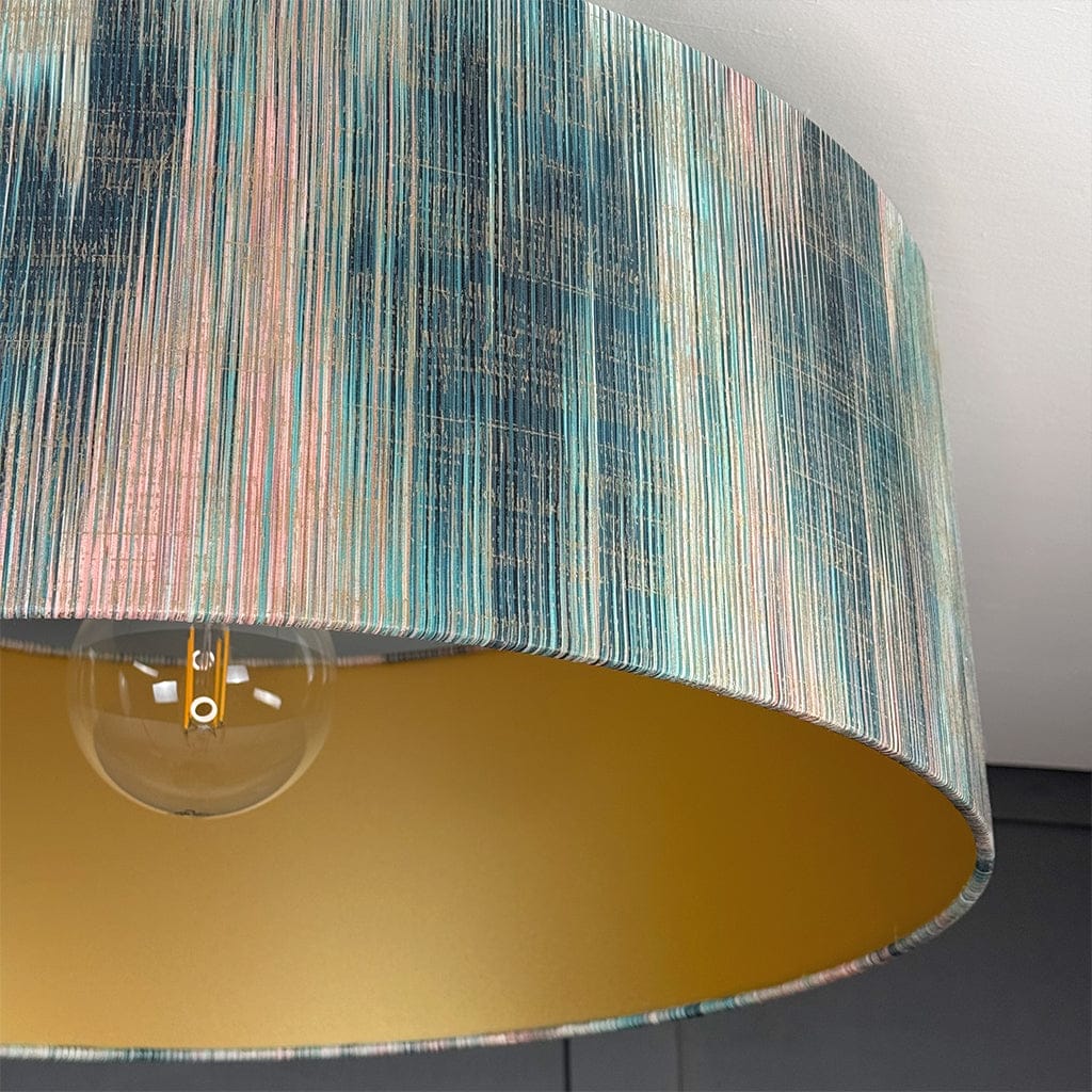 Close-up of a lamp with a colorful striped shade and gold base.