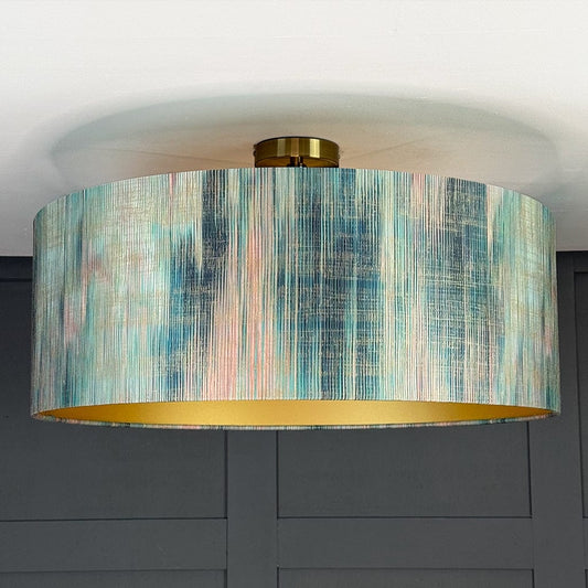 Ceiling light fixture with a colorful drum shade against a gray wall.