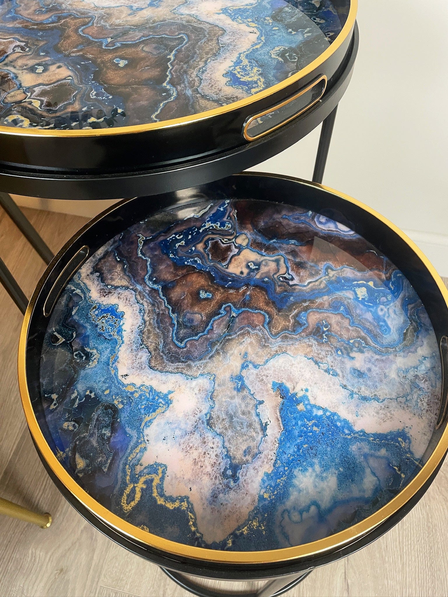 Round marble-patterned table with gold rim on a light wooden floor