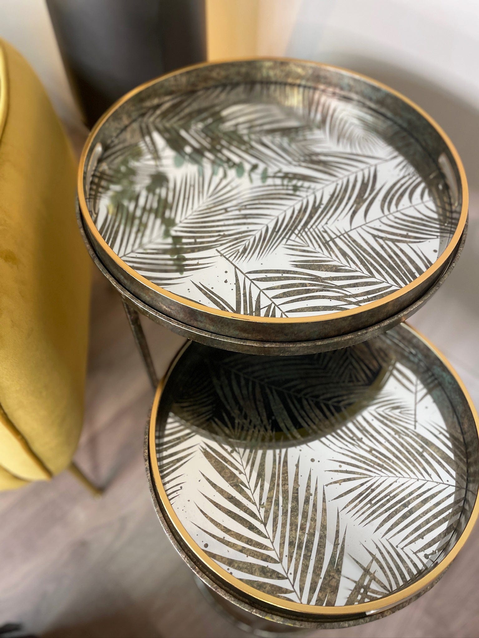 Decorative glass nest of tables with fern leaf pattern on a surface