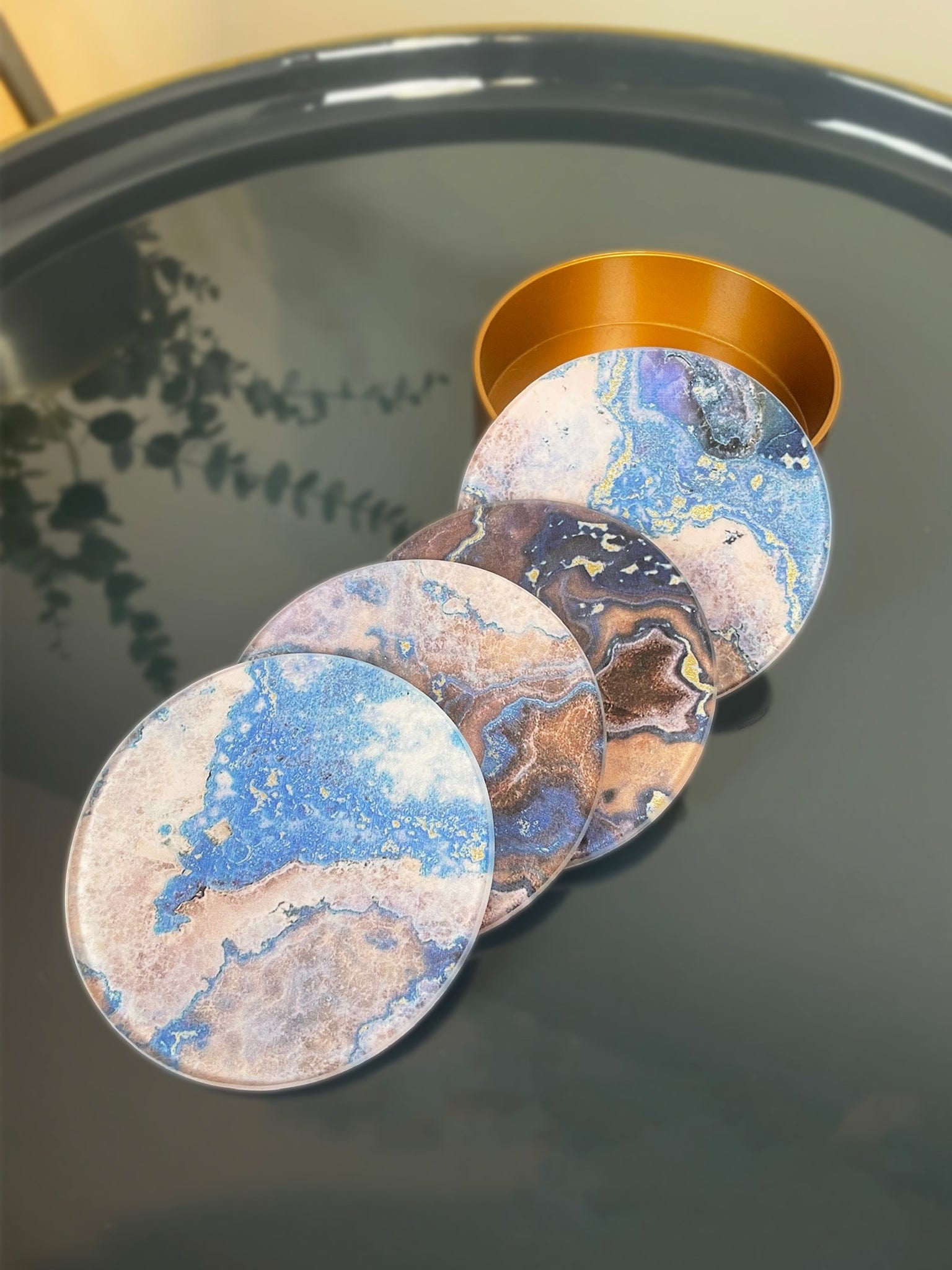 Set of marbled design coasters on a reflective surface